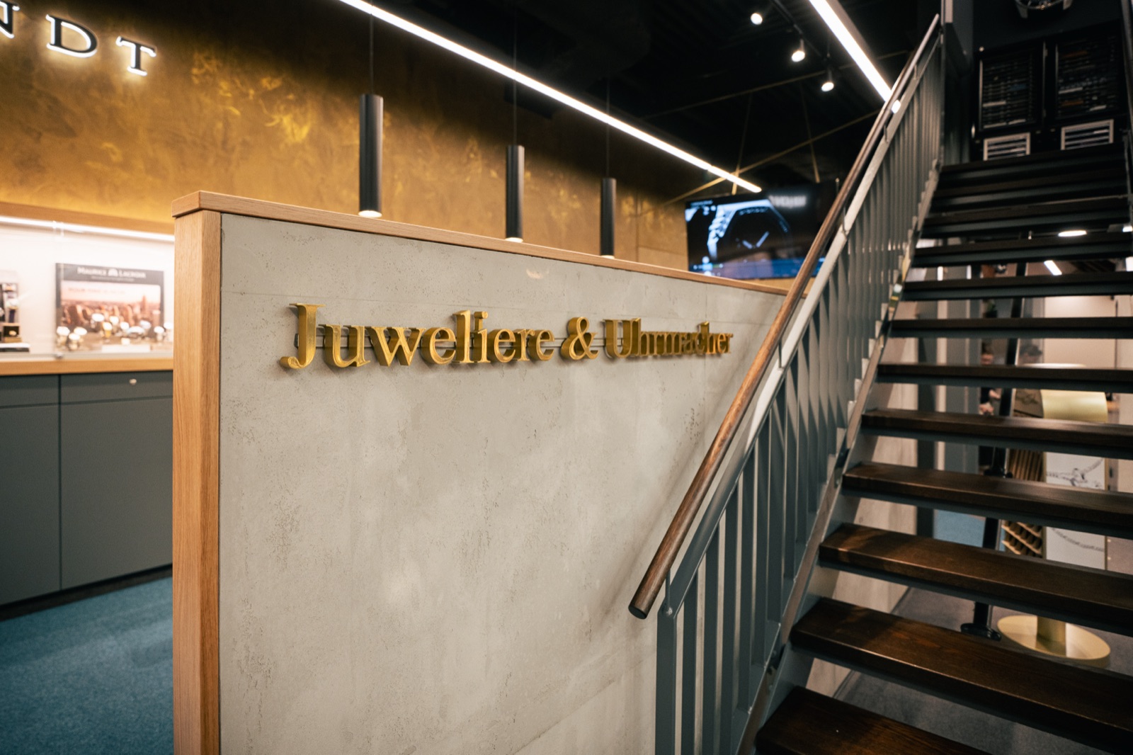 Die Treppe zur oberen Etage mit dem goldenen Schriftzug „Juweliere & Uhrmacher“